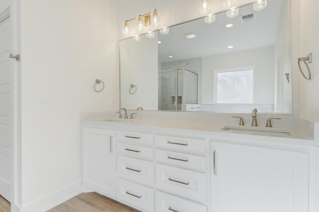 11806 Kenosha Ave, Lubbock, TX 79423 - bathroom with a stall shower, double vanity, wood finished floors, and recessed lighting