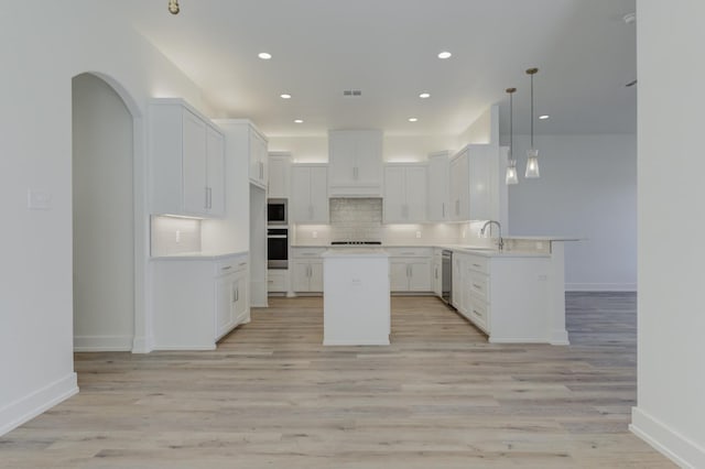11806 Kenosha Ave, Lubbock, TX 79423 - kitchen with appliances with stainless steel finishes, tasteful backsplash, light wood finished floors, a peninsula, and white cabinets