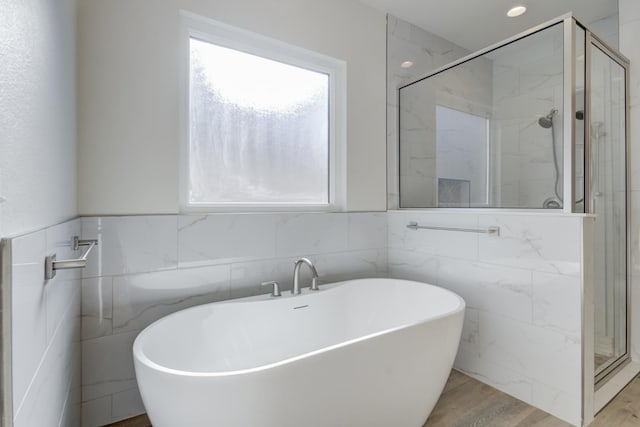 11806 Kenosha Ave, Lubbock, TX 79423 - bathroom featuring a freestanding tub, a marble finish shower, tile walls, and wood finished floors