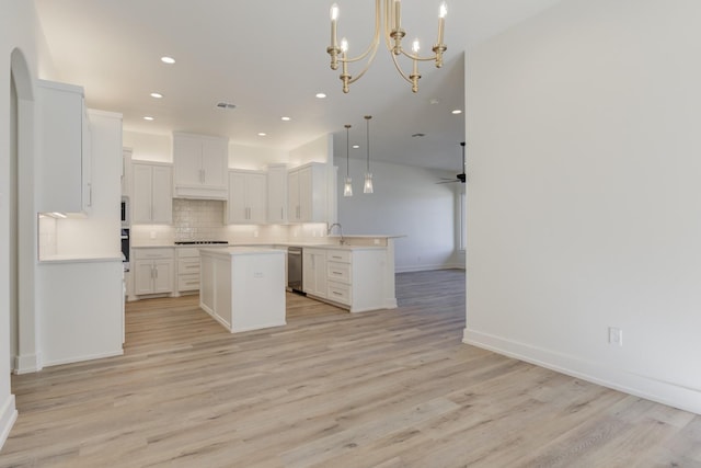 11806 Kenosha Ave, Lubbock, TX 79423 - kitchen featuring open floor plan, light wood finished floors, decorative backsplash, light countertops, and a kitchen island