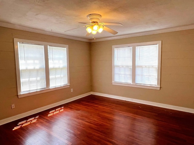 spare room featuring dark wood-type flooring, ornamental molding, plenty of natural light, and a textured ceiling