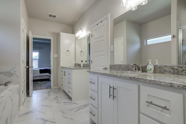 ensuite bathroom with marble finish floor, a sink, a wealth of natural light, and visible vents
