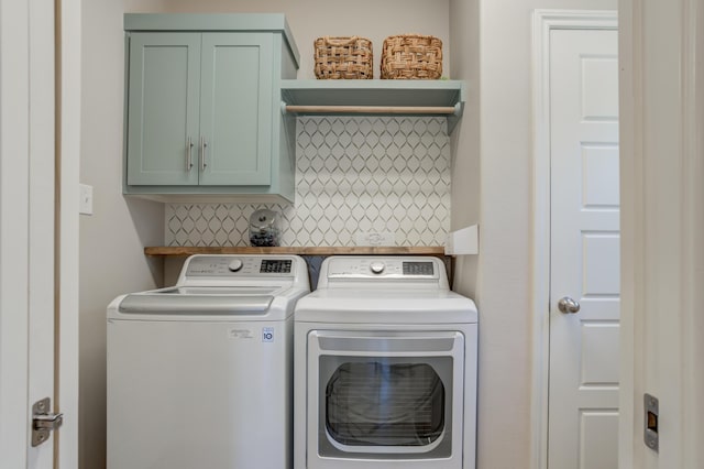 clothes washing area with cabinet space and separate washer and dryer