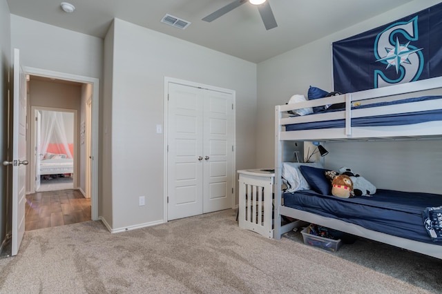 carpeted bedroom featuring baseboards, visible vents, ceiling fan, and a closet