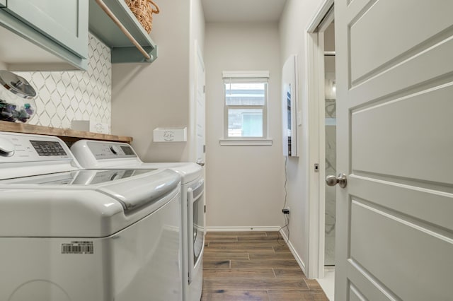 washroom featuring dark wood-type flooring, separate washer and dryer, cabinet space, and baseboards
