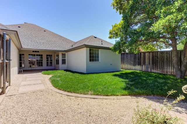 back of property featuring a patio area and a lawn