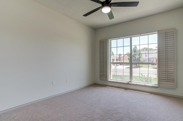 carpeted spare room with ceiling fan and a textured ceiling