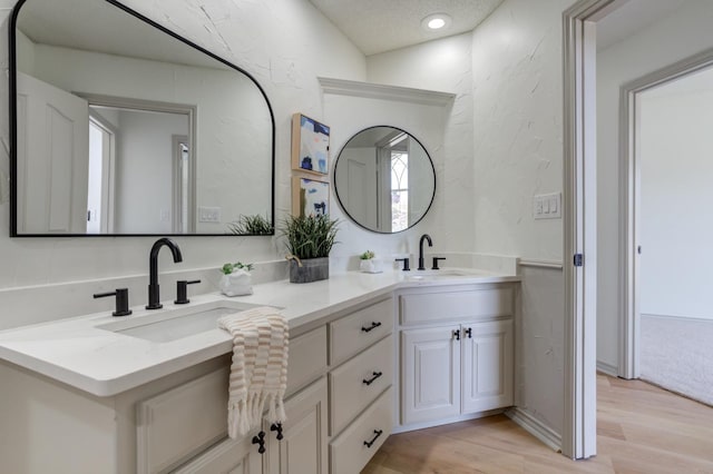 bathroom featuring vanity, hardwood / wood-style flooring, and a textured ceiling