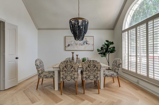 dining room featuring light parquet floors, ornamental molding, lofted ceiling, and an inviting chandelier