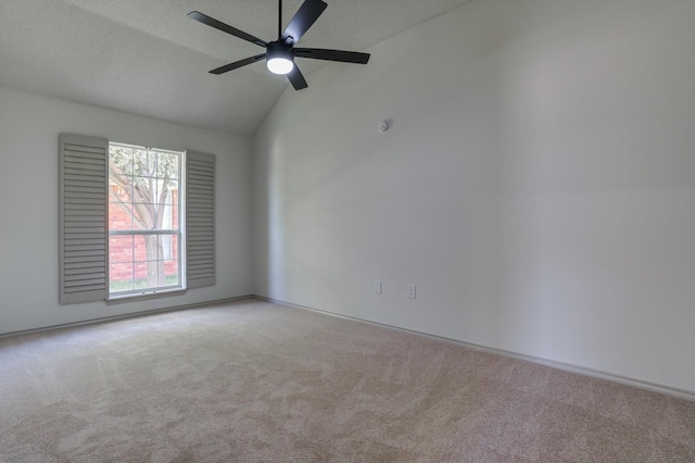 carpeted spare room featuring ceiling fan, lofted ceiling, and a textured ceiling