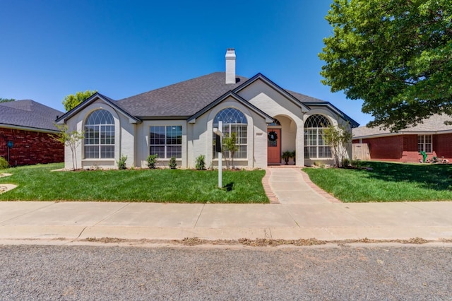 ranch-style home with a front lawn