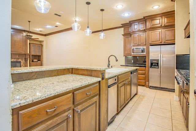 kitchen featuring stainless steel appliances, crown molding, brown cabinetry, and a sink