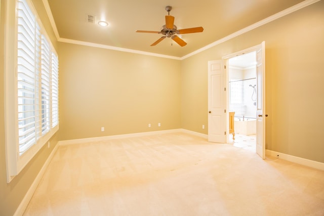 spare room with a ceiling fan, visible vents, light colored carpet, and plenty of natural light