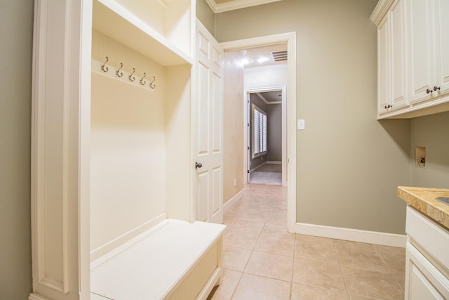 mudroom with light tile patterned flooring, visible vents, crown molding, and baseboards