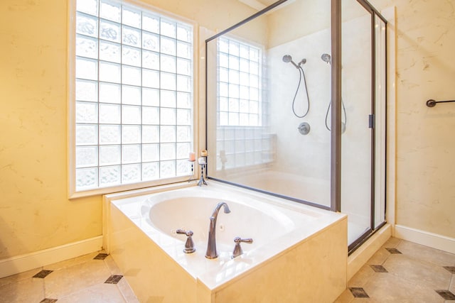 bathroom with tile patterned floors, baseboards, a shower stall, and a garden tub