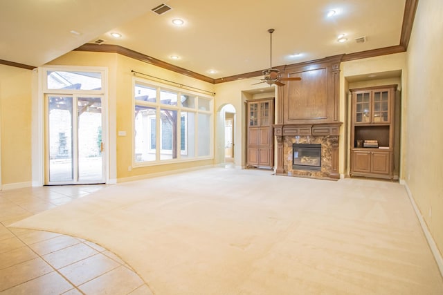 unfurnished living room with a fireplace, visible vents, ornamental molding, and baseboards