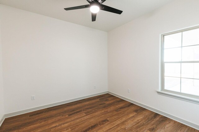 spare room with ceiling fan, baseboards, and dark wood-style flooring