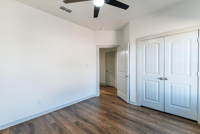 unfurnished bedroom featuring visible vents, a closet, baseboards, ceiling fan, and dark wood-style flooring