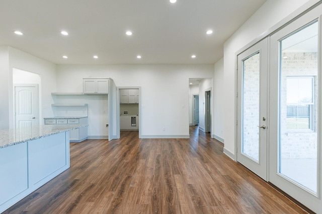 unfurnished living room with dark wood finished floors, recessed lighting, a healthy amount of sunlight, and french doors