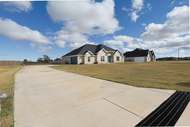 view of front of home with a front yard, fence, a garage, and driveway