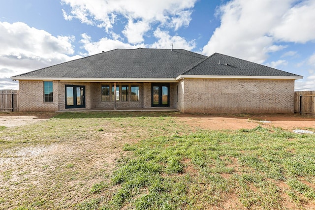 back of property with french doors and a yard