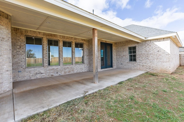 rear view of property featuring a patio and brick siding