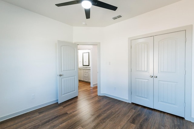 unfurnished bedroom featuring a closet, dark hardwood / wood-style floors, and ceiling fan