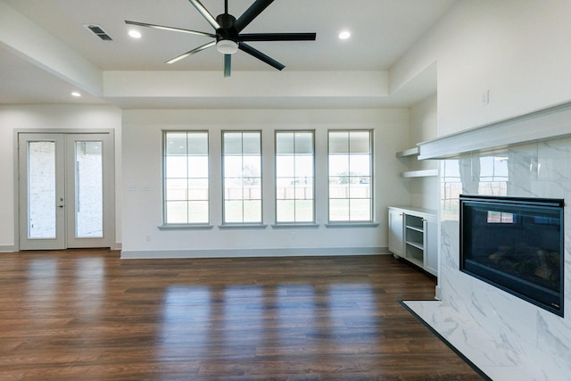 unfurnished living room featuring visible vents, dark wood finished floors, recessed lighting, a fireplace, and french doors