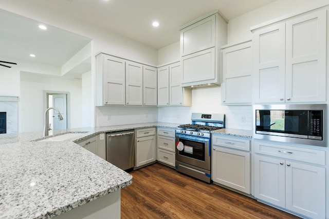 kitchen with stainless steel appliances, sink, and white cabinets