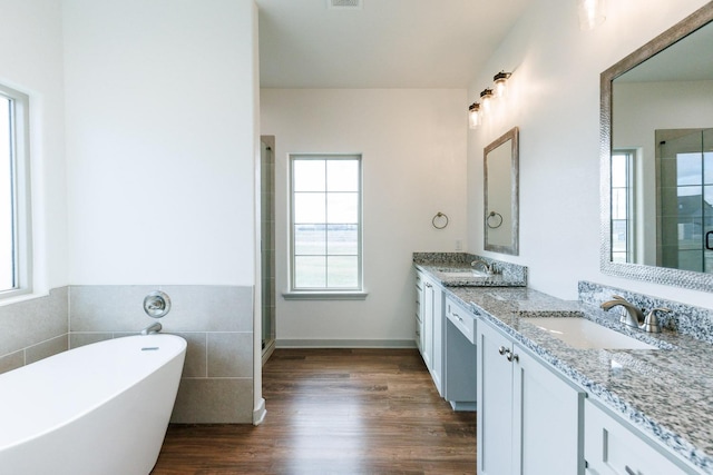 full bathroom featuring a stall shower, a sink, wood finished floors, double vanity, and a soaking tub