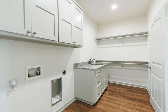 washroom featuring dark wood-type flooring, sink, cabinets, hookup for a washing machine, and hookup for an electric dryer