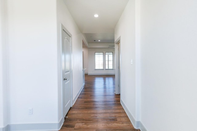 hall featuring recessed lighting, baseboards, and dark wood-style flooring