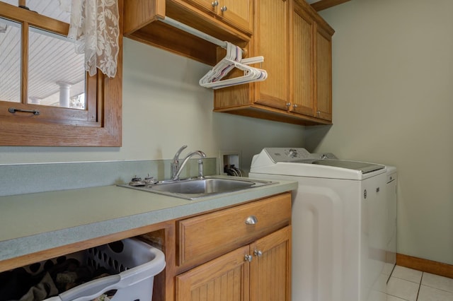 laundry area with cabinets, washing machine and dryer, sink, and light tile patterned floors