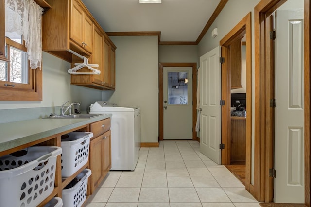 laundry room featuring light tile patterned flooring, sink, crown molding, cabinets, and washing machine and dryer