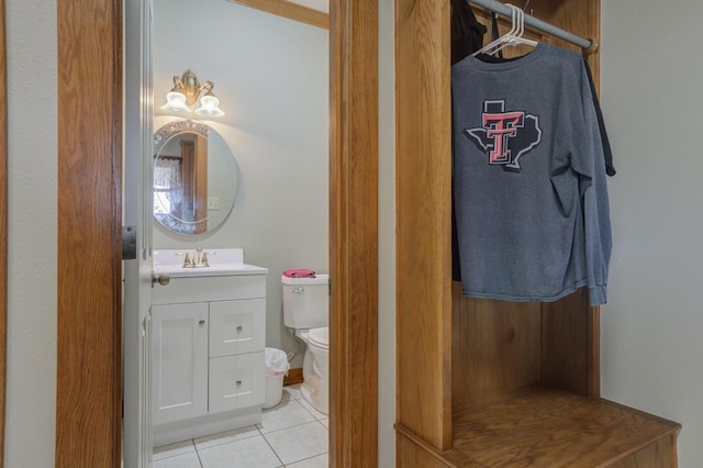 bathroom with tile patterned flooring, vanity, and toilet