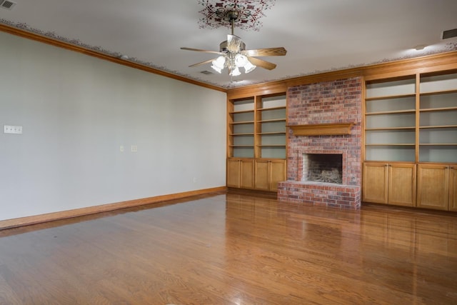 unfurnished living room featuring built in features, a fireplace, ceiling fan, crown molding, and light hardwood / wood-style flooring