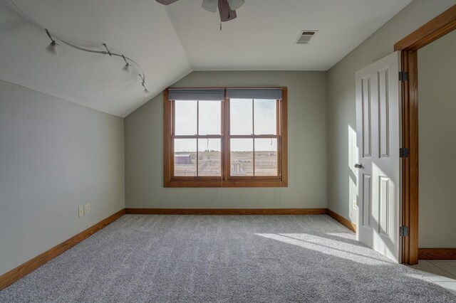 additional living space featuring lofted ceiling, light colored carpet, and ceiling fan