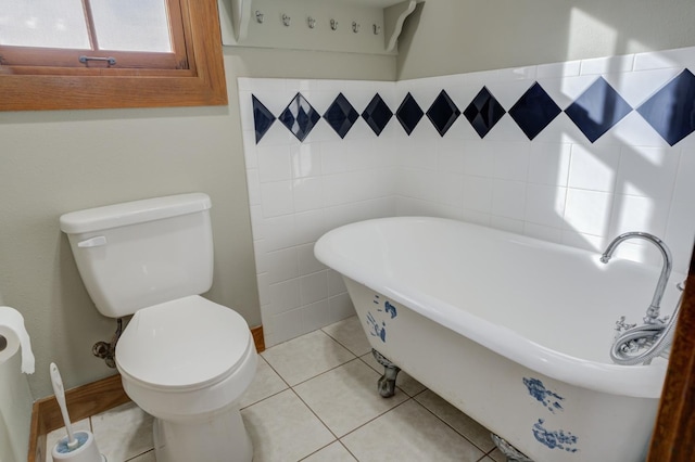 bathroom featuring tile patterned floors, toilet, and a washtub