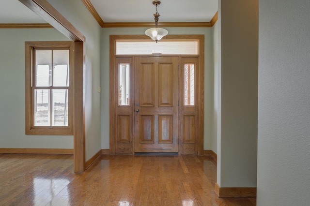 foyer entrance featuring ornamental molding and light hardwood / wood-style flooring