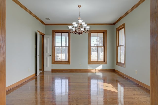 spare room with ornamental molding and a chandelier