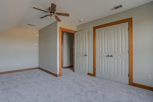 unfurnished bedroom featuring vaulted ceiling, light colored carpet, a closet, and ceiling fan