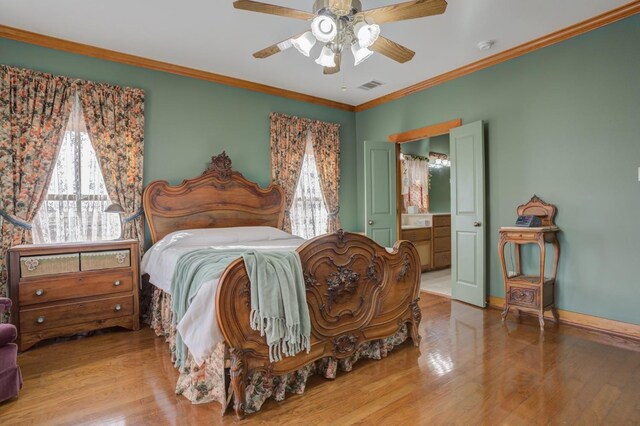 bedroom with hardwood / wood-style flooring, crown molding, ensuite bathroom, and ceiling fan