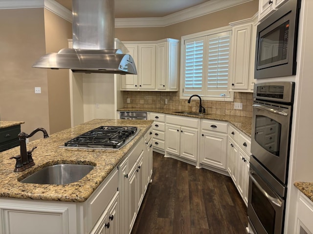 kitchen featuring white cabinetry, island exhaust hood, appliances with stainless steel finishes, and sink