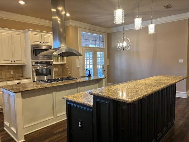 kitchen featuring light stone counters, island range hood, a kitchen island, stainless steel appliances, and white cabinets