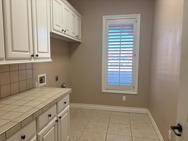 laundry area with cabinets, light tile patterned flooring, electric dryer hookup, and hookup for a washing machine