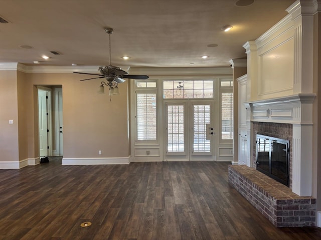 unfurnished living room featuring ornamental molding, dark wood-type flooring, ceiling fan, and a fireplace