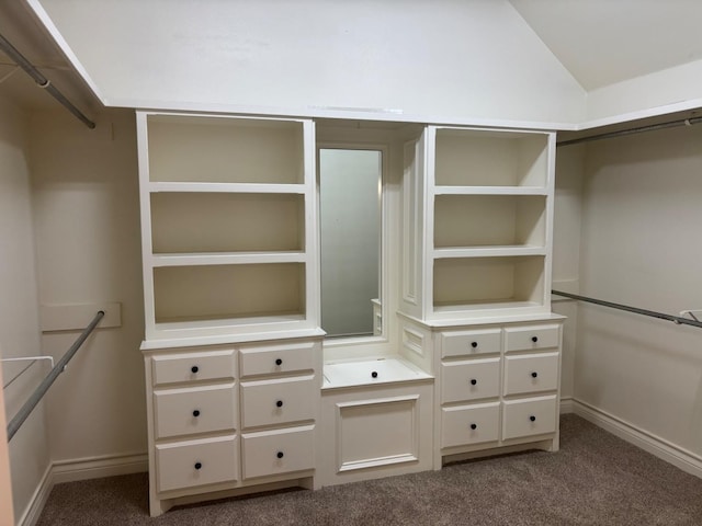 walk in closet with carpet floors and vaulted ceiling