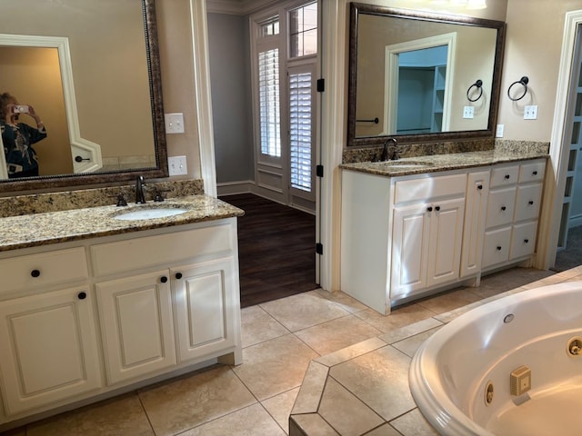 bathroom with vanity, a relaxing tiled tub, and tile patterned floors