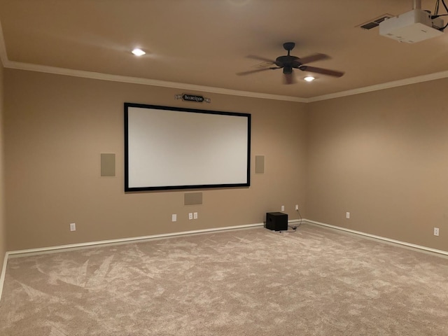 carpeted cinema room featuring crown molding and ceiling fan