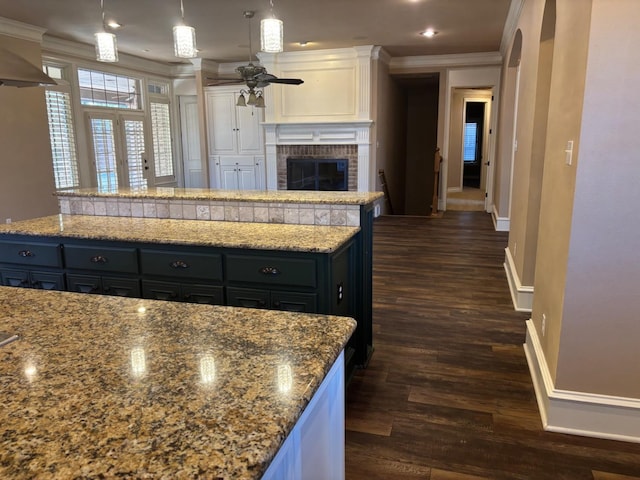 kitchen featuring white cabinetry, crown molding, decorative light fixtures, dark hardwood / wood-style floors, and a kitchen island